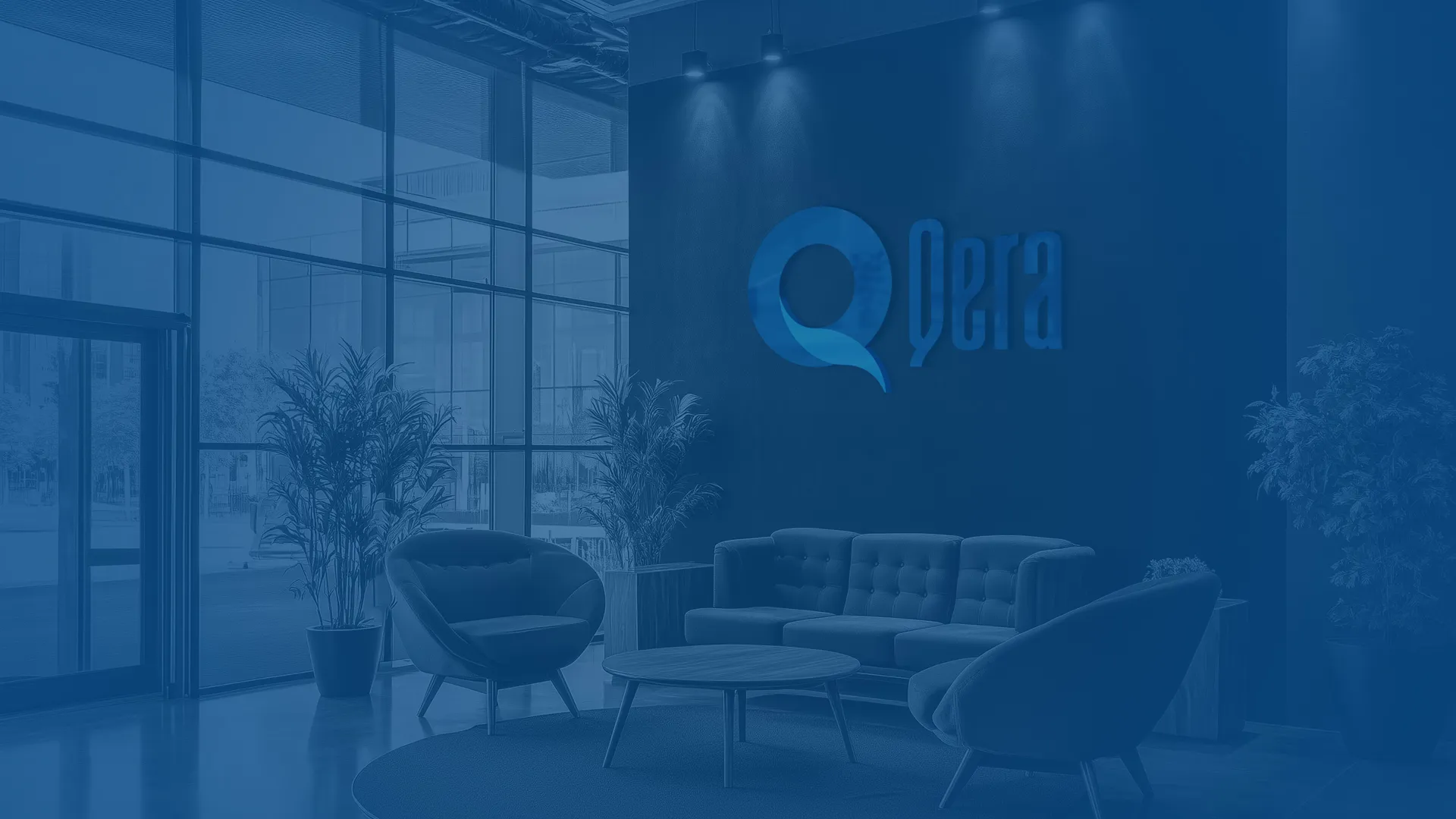 Qera office lobby — embossed Qera logo on the wall, a corporate work environment